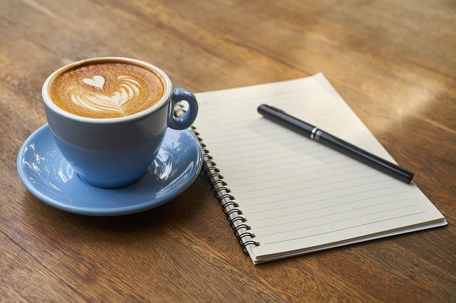 Writing a eulogy for a mother - a notebook, a pen and a cup of coffee with a heart